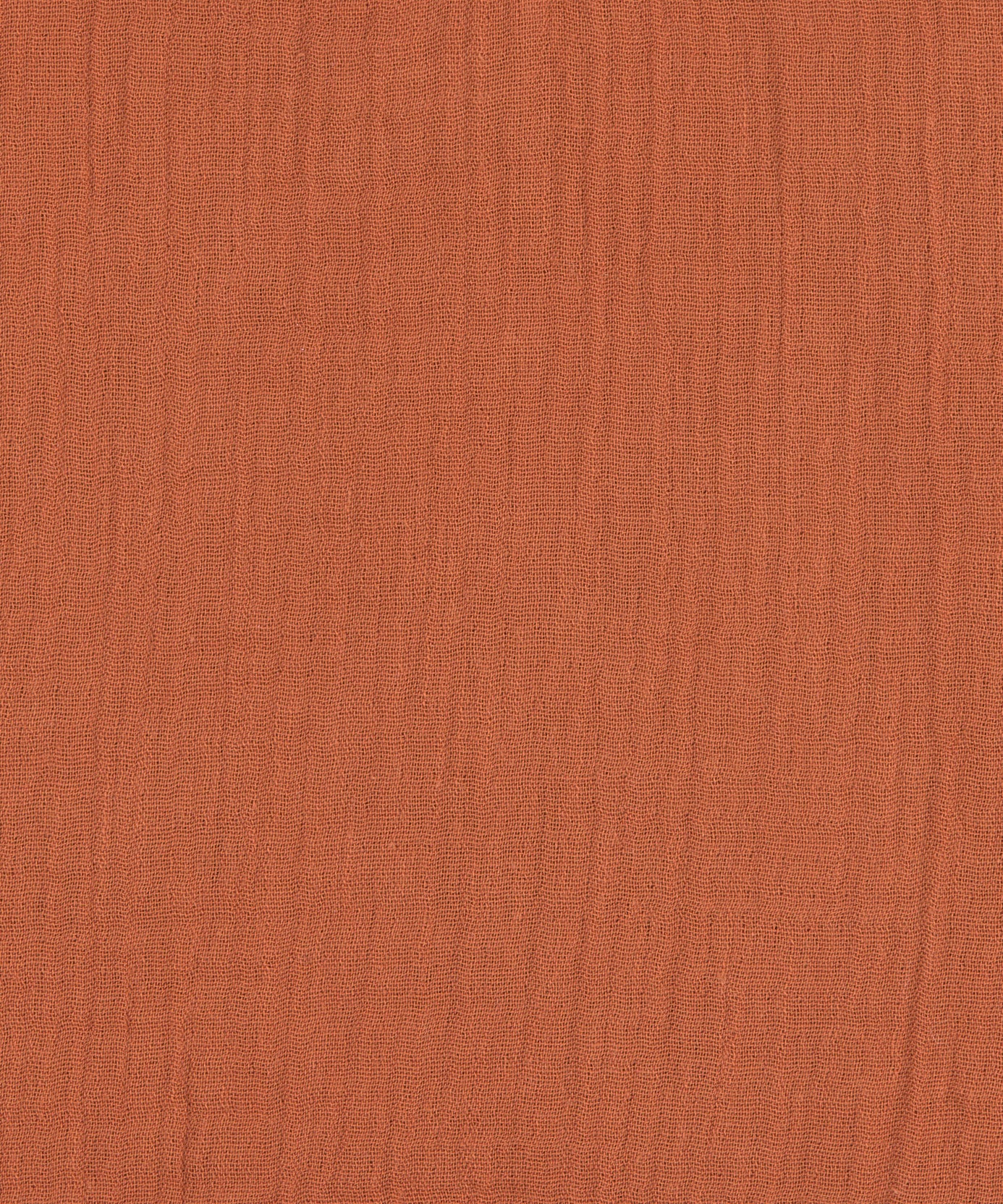A closeup of the Lassig organic cotton muslin bandana dribble bib in a lovely orange rust colour