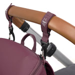 The Lassig Slender Up Nappy change backpack in deep red, attached to a pram with the included pram clips.