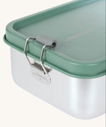 A close up of the clamp latch closure on the Lassig Stainless Steel Lunchbox with a Unique Olive Green colour lid. These stainless steel lunchboxes have a removable divider inside. 
