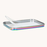 The lid of the Lassig Stainless Steel Lunchbox in a  Solid Bold Rainbow design showing the silicone seal. A stainless steel lunchbox with removable divider featuring an iridescent rainbow coloured lid. This lunchbox is part of a wide range of reusable items available at Babipur. 