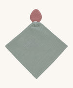 The Lassig organic cotton muslin comforter in green, with a strawberry shaped rubber teether attached to the top. 