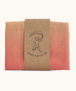 Laura's Play Cotton pastel rainbow gradient playcloth, made from 100% organic cotton held by a decorative cardboard strip