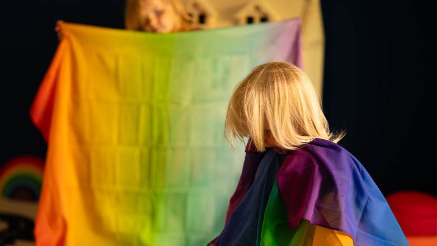 Children playing with Laura's Play Cotton organic cotton play cloths in rainbow colours.