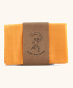 Laura's 100% organic cotton small play cloth in orange held together by a decorated cardboard strip