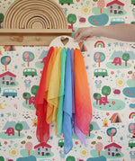 Laura's Play Cotton large Wooden Display holder with heart cut out with 7 play cloths inside placed on a peg shelf.