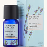 Lavender pure essential oil in a blue glass bottle in front of a decorative blue cardboard box.