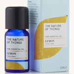 Organic lemon pure essential oil in a blue glass bottle in front of a decorative blue cardboard box.