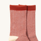 A close up of the Little Green Radicals brown striped ankle showing the zig zag striped detail on organic cotton fabric with light brown and cream trim.