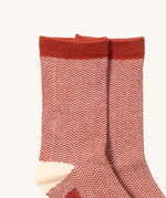 A close up of the Little Green Radicals brown striped ankle showing the zig zag striped detail on organic cotton fabric with light brown and cream trim.
