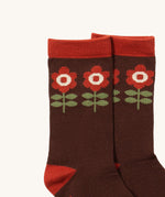 A close up of the Little Green Radicals flowers ankle showing the retro flowers inspired design on brown organic cotton fabric with light brown trim.