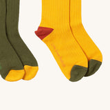 A close up of the yellow block Little Green Radicals ankle socks showing the red and green toe trim detail on soft ribbed organic cotton fabric