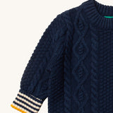 A close up of the Little Green Radicals navy aran knitted jumper available at Babipur. Showing the cable knit and the thick collar detail on dark navy organic cotton fabric