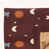 A close up of the Little Green Radicals baby blanket in flying birds. Showing the design detail and yellow striped embroidery inner liner on brown organic cotton fabric
