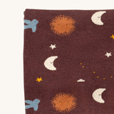 A close up of the Little Green Radicals baby blanket in flying birds. Showing the design detail on brown organic cotton fabric.