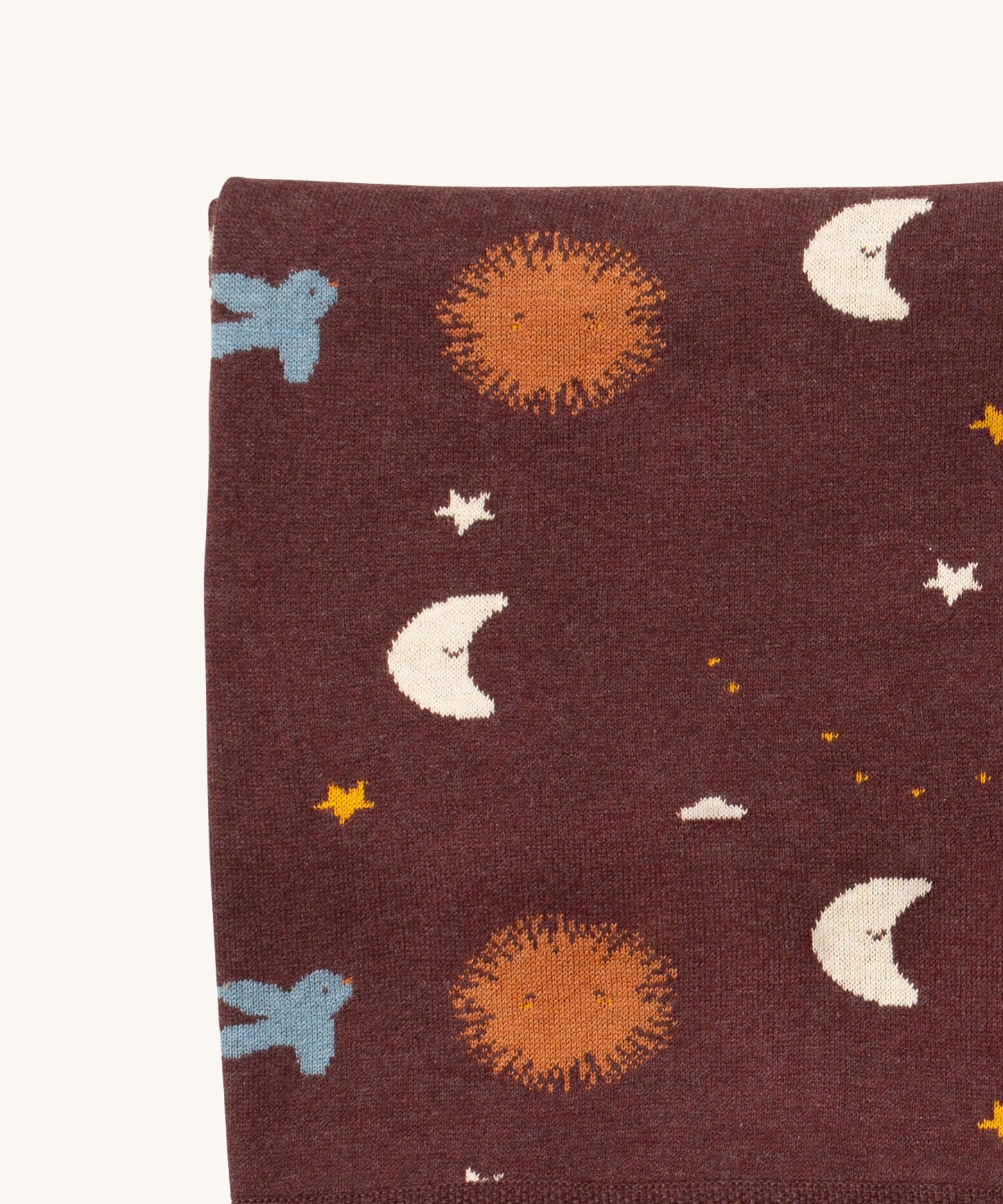 A close up of the Little Green Radicals baby blanket in flying birds. Showing the design detail on brown organic cotton fabric.