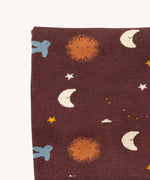 A close up of the Little Green Radicals baby blanket in flying birds. Showing the design detail on brown organic cotton fabric.