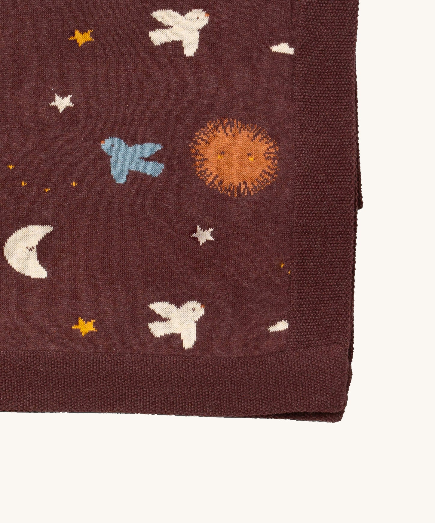 A close up of the Little Green Radicals baby blanket in flying birds. Showing the design detail and brown textured trim on organic cotton fabric.