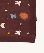 A close up of the Little Green Radicals baby blanket in flying birds. Showing the design detail and brown textured trim on organic cotton fabric.