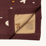 A close up of the Little Green Radicals baby blanket in flying birds. Showing the yellow striped embroidery inner liner on organic cotton fabric