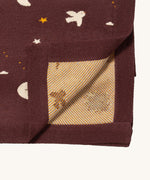 A close up of the Little Green Radicals baby blanket in flying birds. Showing the yellow striped embroidery inner liner on organic cotton fabric