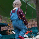 A child walking in the woods and wearing the Little Green Radicals pale blue lined corduory dungarees over the quilted flying birds sweater. Features 2 back pockets and adjustable shoulder straps.