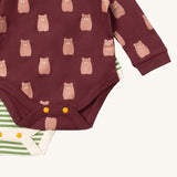 A close up of the striped Little Green Radicals baby body suit underneath the brown bear bodysuit showing yellow popper detail around the crotch and leg hole detail on soft organic cotton fabric