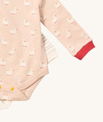 A close up of the puddle ducks Little Green Radicals baby body suit on top of the grey and cream striped bodysuit showing yellow popper detail around the crotch and leg hole detail on soft organic cotton fabric
