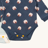 A close up of the sheep Little Green Radicals baby body suit on top of the light blue and cream striped bodysuit showing yellow popper detail around the crotch and leg hole detail on soft organic cotton fabric