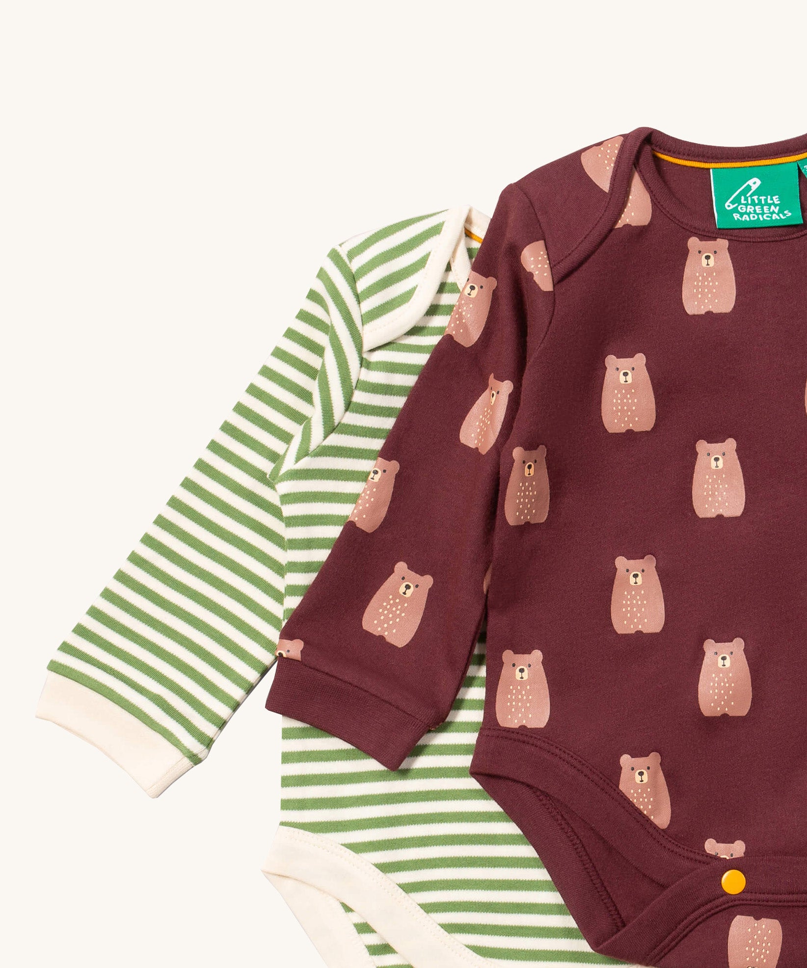 A close up of the brown bear Little Green Radicals baby body suit on top of the striped bodysuit showing collar trim and print detail on soft organic cotton fabric