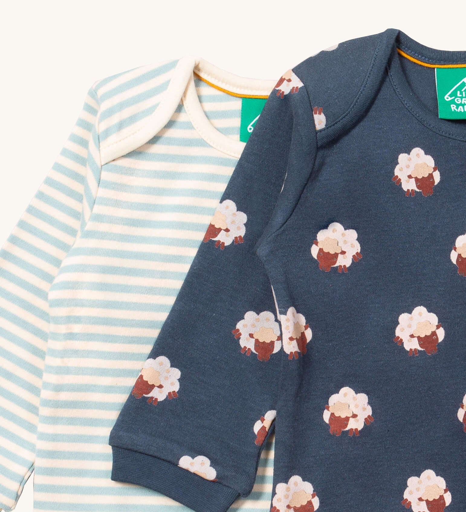 A close up of the sheep Little Green Radicals baby body suit on top of the striped bodysuit showing collar detail and print detail on navy soft organic cotton fabric