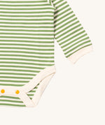 A close up of the striped Little Green Radicals baby body suit showing the green and cream stripe detail and yellow popper detail around the crotch on soft organic cotton fabric