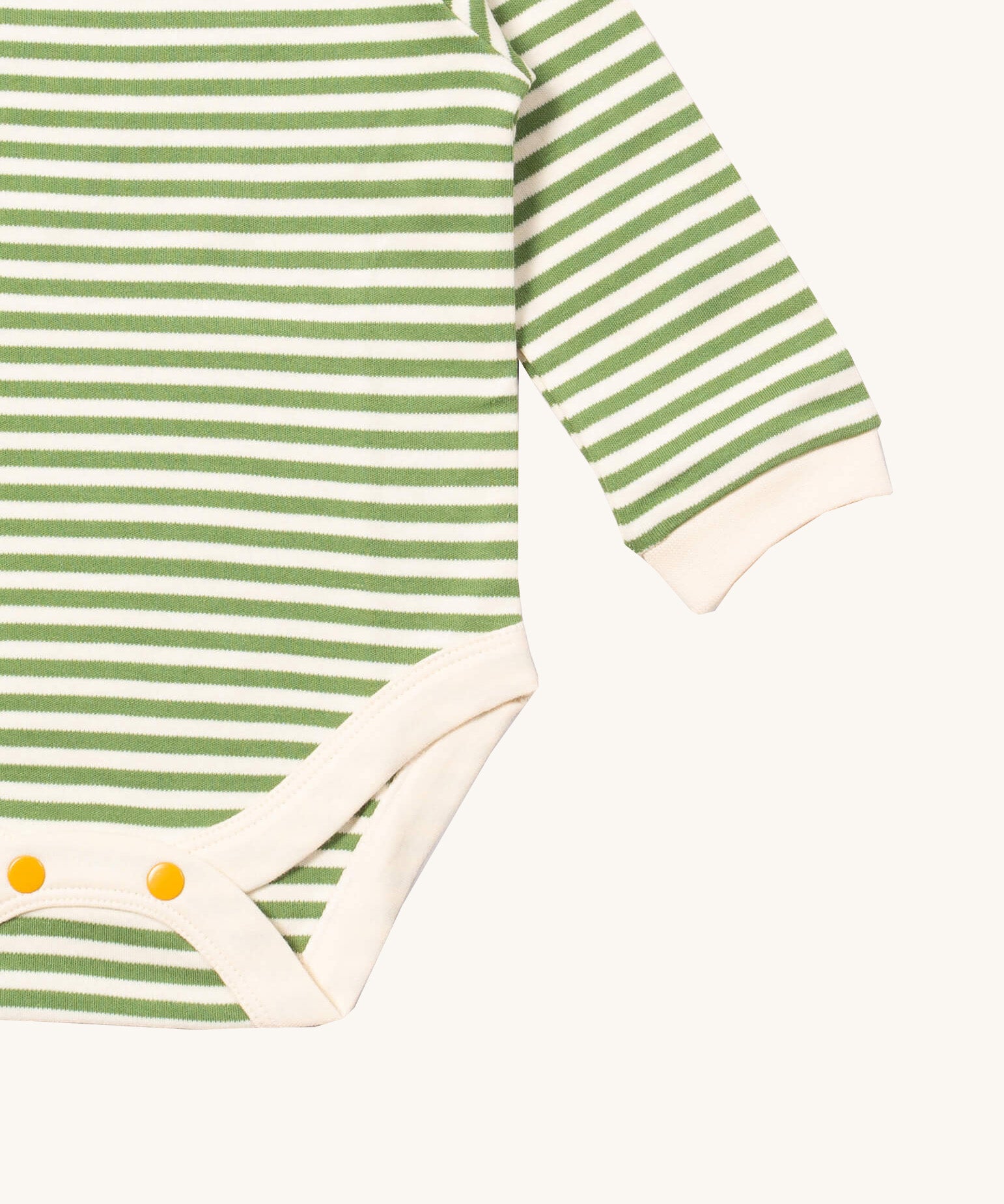 A close up of the striped Little Green Radicals baby body suit showing the green and cream stripe detail and yellow popper detail around the crotch on soft organic cotton fabric