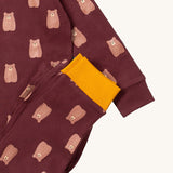 A close up of the Little Green Radicals brown bear pyjama set showing the brown with yellow trim bottom and brown bear detail on organic cotton fabric.