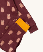 A close up of the Little Green Radicals brown bear pyjama set showing the brown with yellow trim bottom and brown bear detail on organic cotton fabric.