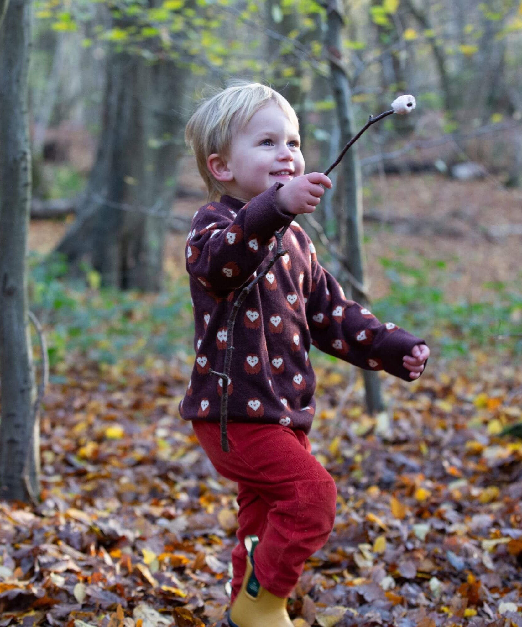 A child wearing the Little Green Radicals brown owl knitted jumper available at Babipur. A soft knit jumper with cute owls and thick cuffs for warmth on brown organic cotton fabric. 