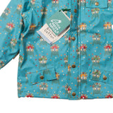 Close up of the childrens LGR recycled leo lion blue rain coat showing the repeated colourful lion pattern on a white background
