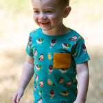 A child playing in a grassy field wearing the Little Green Radicals Garden Birds Organic T-Shirt & Jogger Playset