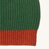 A close up of the Little Green Radicals knitted beanie in chive. Showing the thick red knit brim detail on organic cotton fabric
