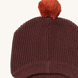 A close up of the Little Green Radicals chocolate knitted beanie hat showing the knit detail on brown organic cotton fabric.
