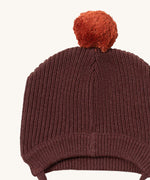 A close up of the Little Green Radicals chocolate knitted beanie hat showing the knit detail on brown organic cotton fabric.