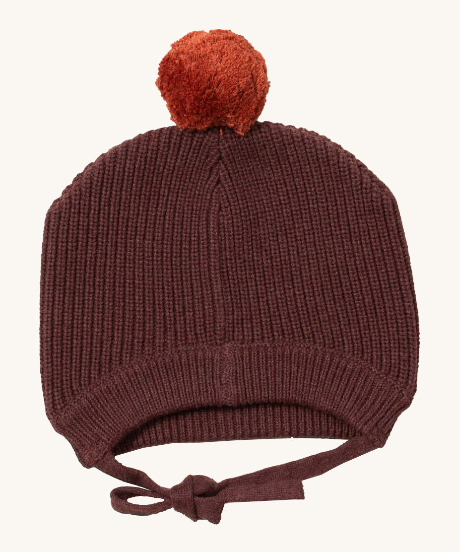 Little Green Radicals chocolate knitted beanie hat available at Babipur. A brown knitted GOTS organic cotton beanie style hat with a light brown pom pom on top. Features matching brown ties for a secure fit.