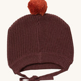 Little Green Radicals chocolate knitted beanie hat available at Babipur. A brown knitted GOTS organic cotton beanie style hat with a light brown pom pom on top. Features matching brown ties for a secure fit.