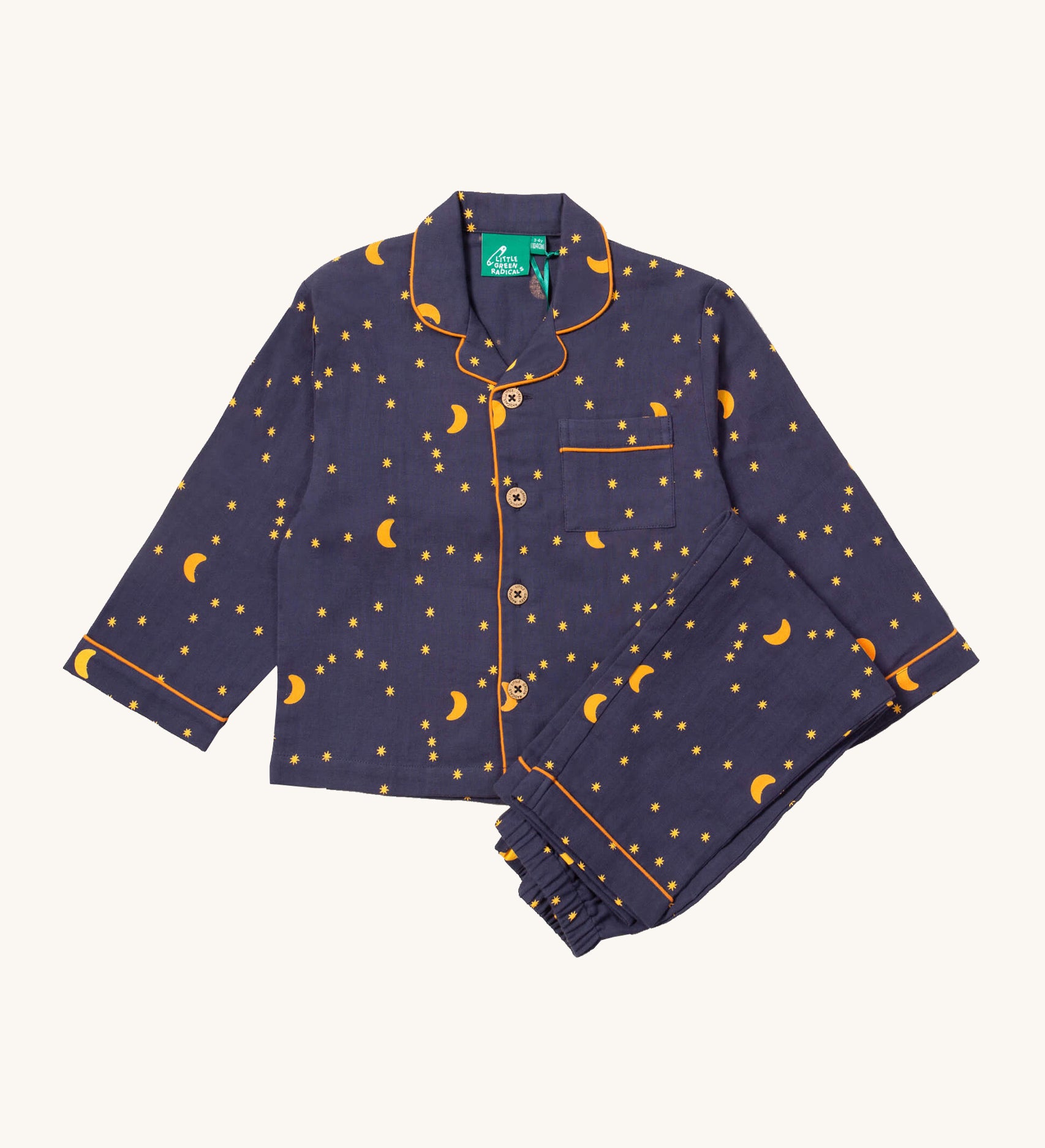 Little Green Radicals classic pyjama set in dark night available at Babipur. A GOTS organic cotton pyjama set including a long sleeve shirt style top in navy with yellow trim and a starry night print and matching navy bottoms.