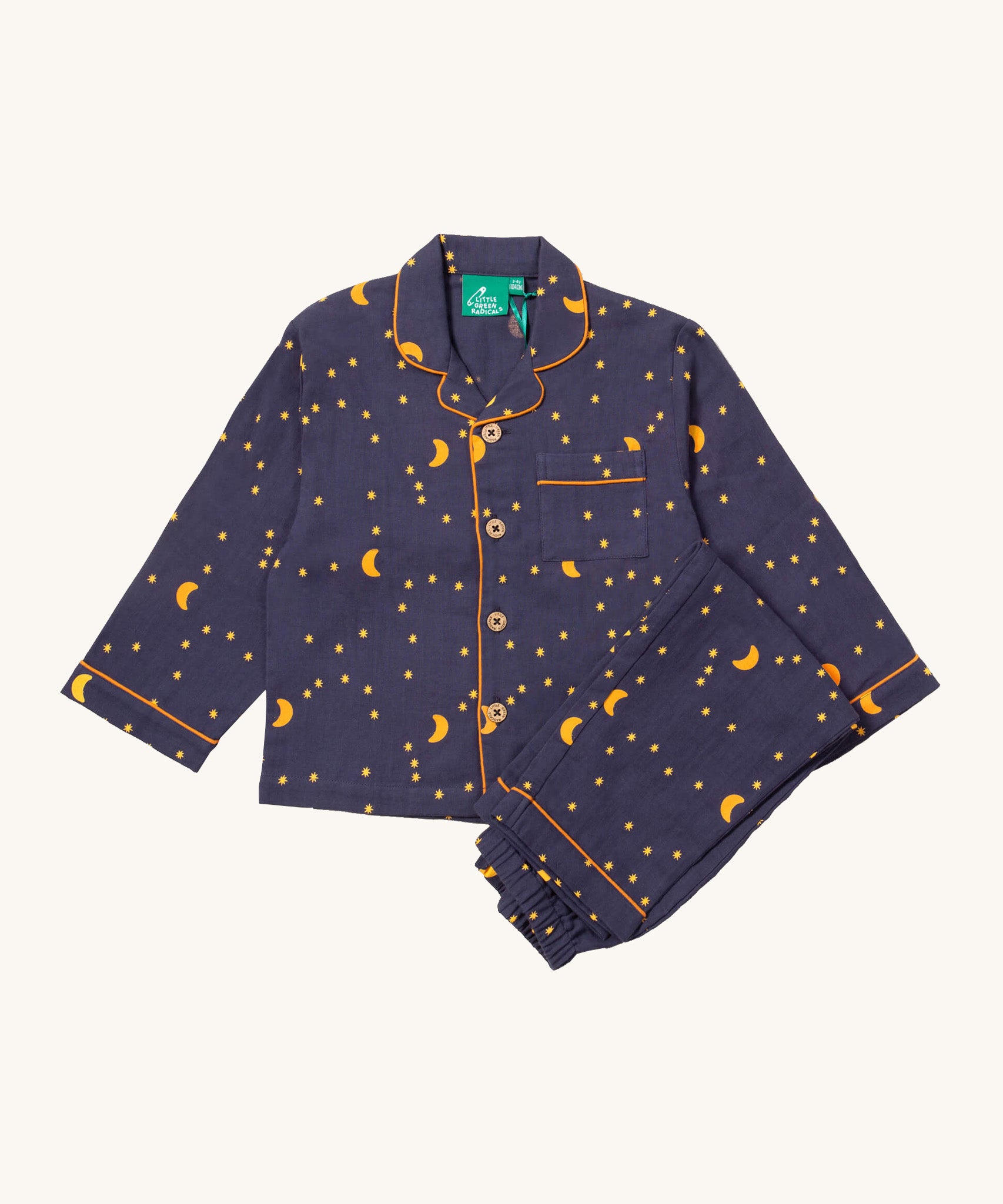 Little Green Radicals classic pyjama set in dark night available at Babipur. A GOTS organic cotton pyjama set including a long sleeve shirt style top in navy with yellow trim and a starry night print and matching navy bottoms.