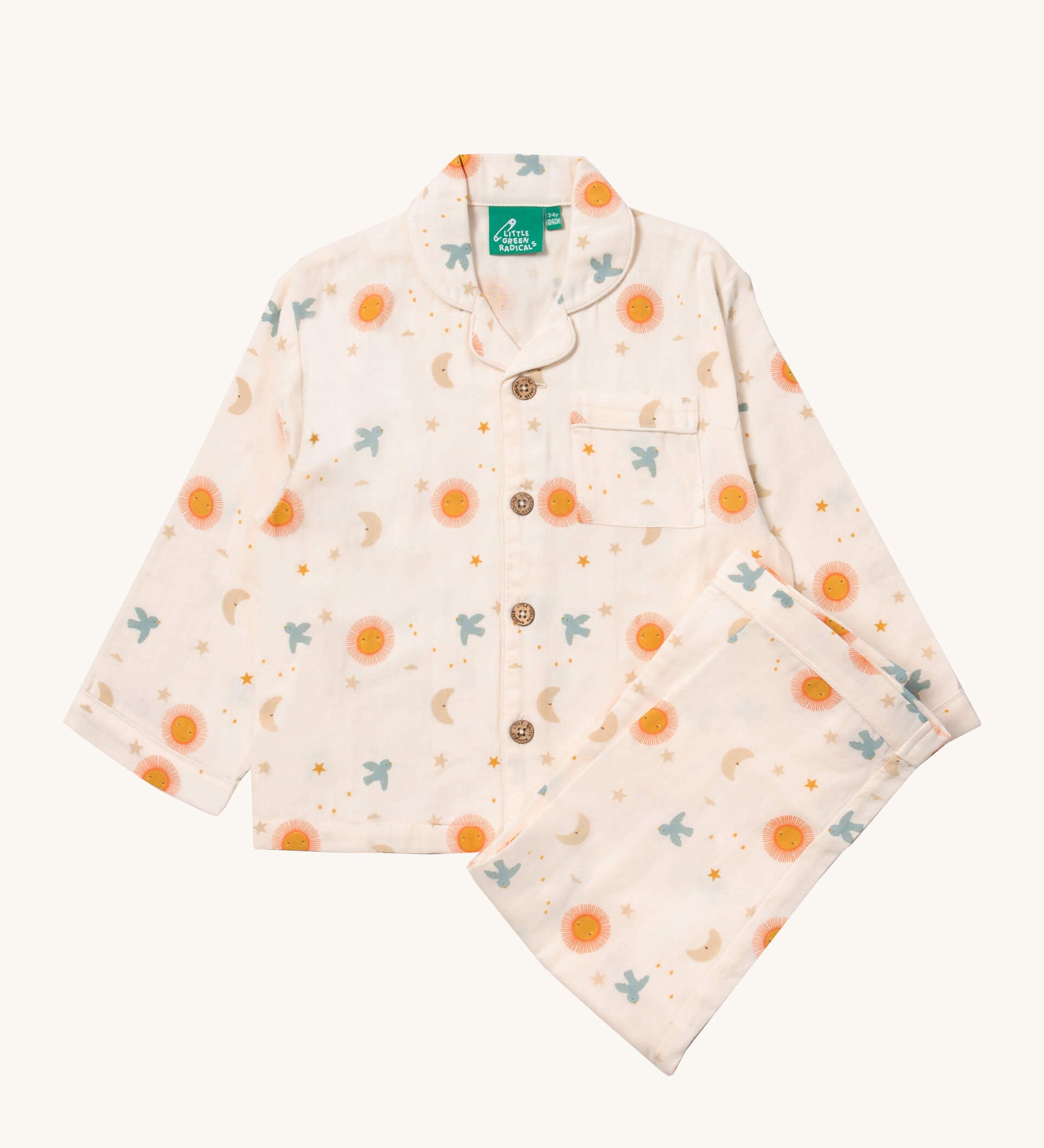 Little Green Radicals classic pyjama set in moon and sun available at Babipur. A GOTS organic cotton pyjama set including a long sleeve shirt style top in light pink with prints of cute birds flying through stars the moon and sun also includes matching bottoms