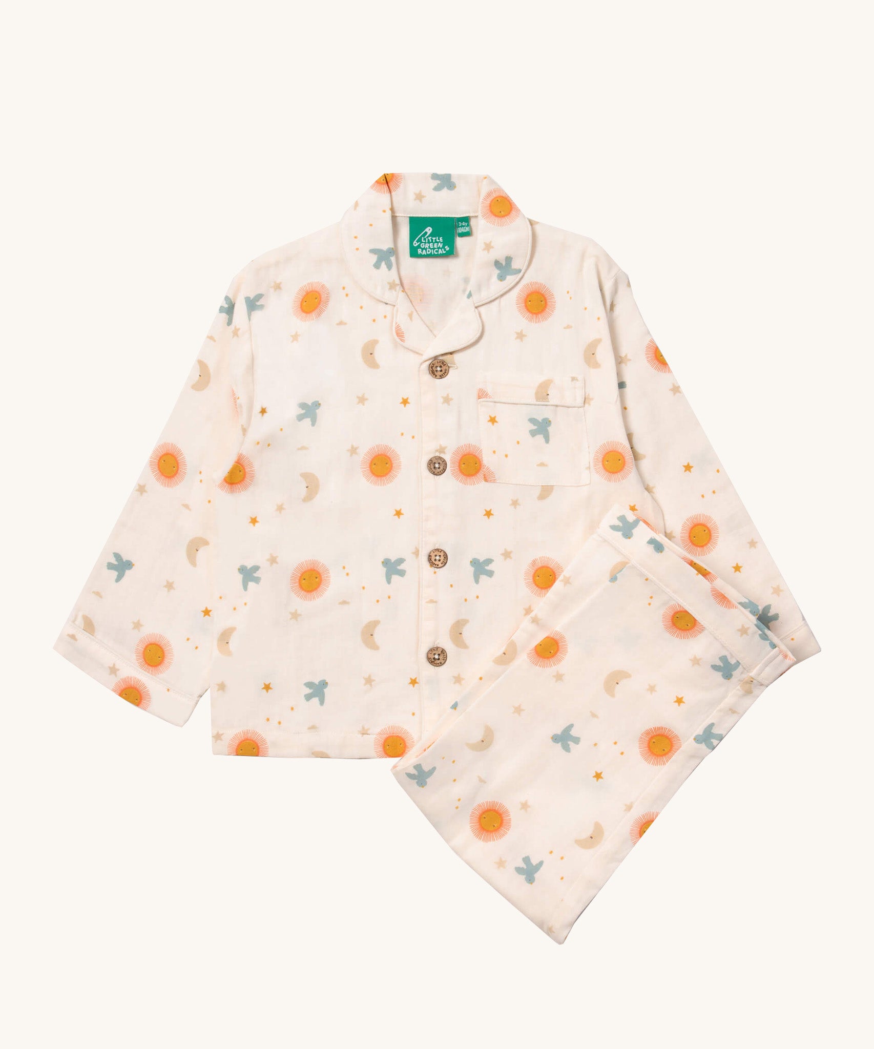 Little Green Radicals classic pyjama set in moon and sun available at Babipur. A GOTS organic cotton pyjama set including a long sleeve shirt style top in light pink with prints of cute birds flying through stars the moon and sun also includes matching bottoms