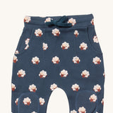 A close up of the Little Green Radicals comfy joggers in sleeping sheep showing the pocket, drawstring and kneepatch detail on navy organic cotton fabric