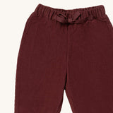 A close up of the Little Green Radicals comfy trousers in chocolate corduroy. Showing the corduroy detail and matching drawstring in dark maroon soft GOTS organic cotton fabric