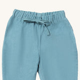 A close up of the Little Green Radicals comfy trousers in pale blue corduroy. Showing the corduroy detail and matching drawstring in pastel blue soft GOTS organic cotton fabric