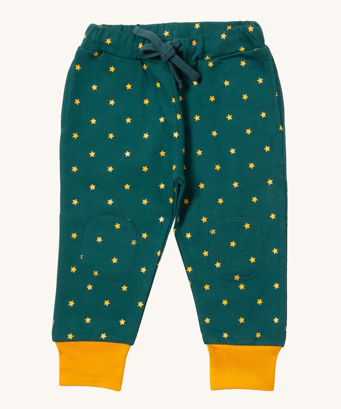 Little Green Radicals cosy joggers in golden stars available at Babipur.. A soft GOTS organic cotton dark turquoise jogger pants with yellow stars and matching yellow trim. Features 2 side pockets a matching turquoise waist drawstring and knee patches.